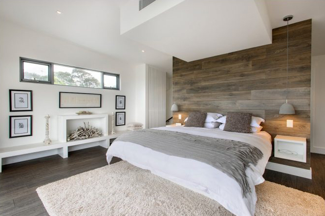 Airy bedroom with light wood flooring and wood plank accent wall