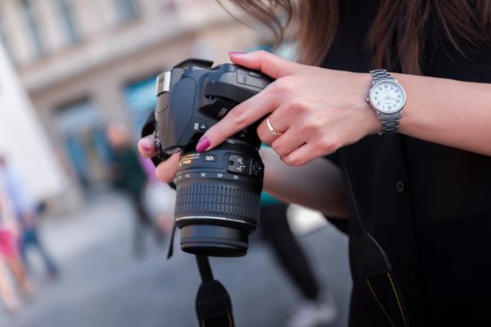 woman holding DSLR camera on street